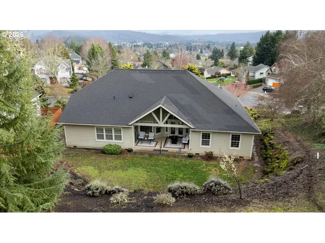 a aerial view of a house with a yard and large trees