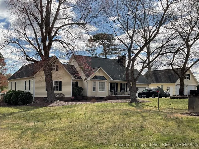 a front view of a house with a yard covered in snow