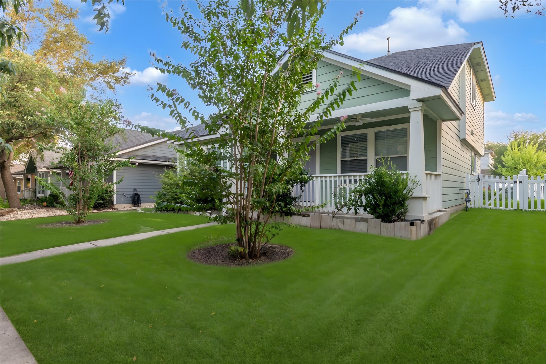A well-maintained lawn and mature trees frame this charming residence with a welcoming front porch.