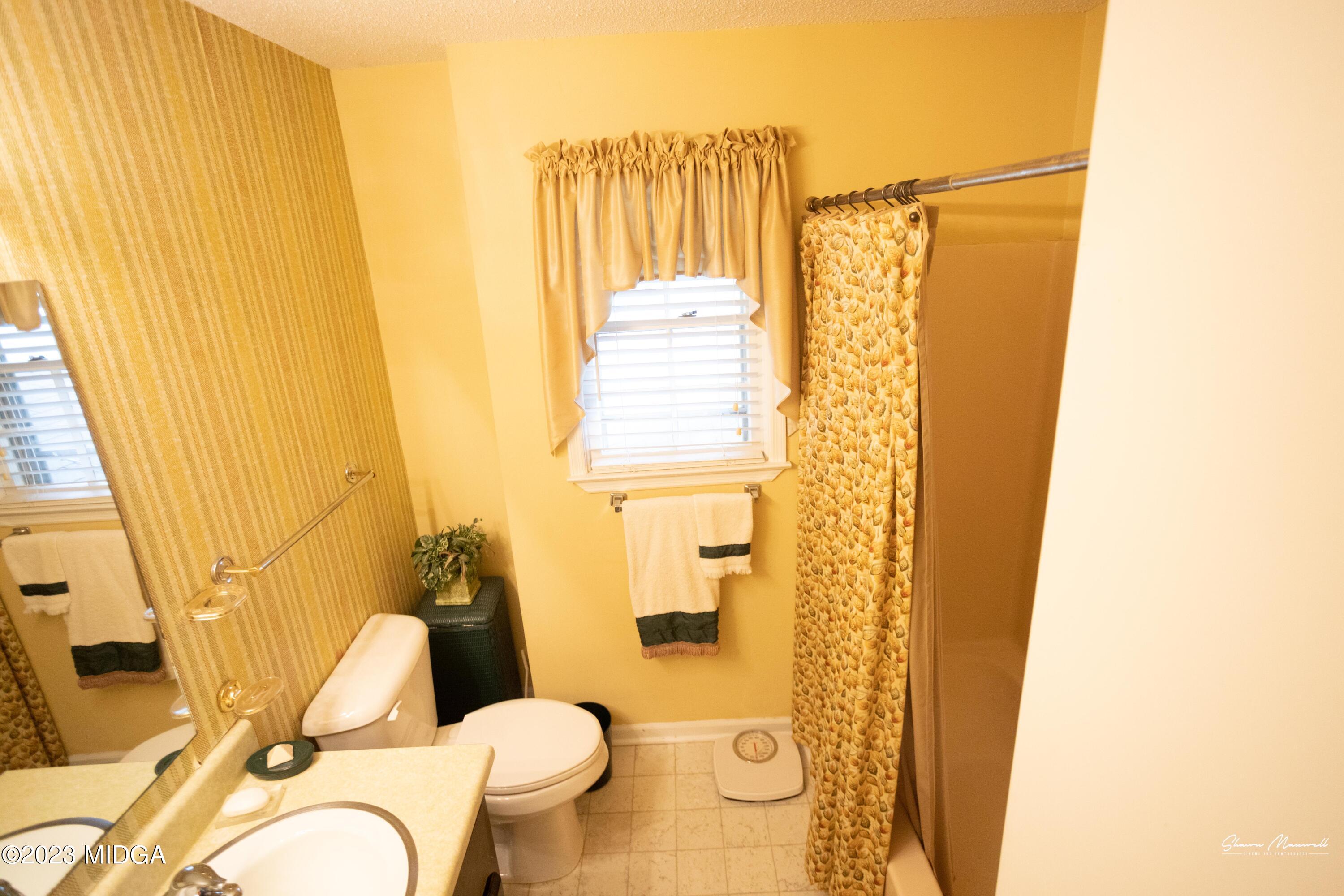 2885 Portland Place Macon, GA 31211 - Photo 17 of 26 a bathroom with a sink and mirror with toilet