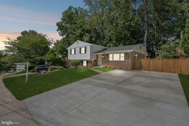a front view of a house with a yard and trees
