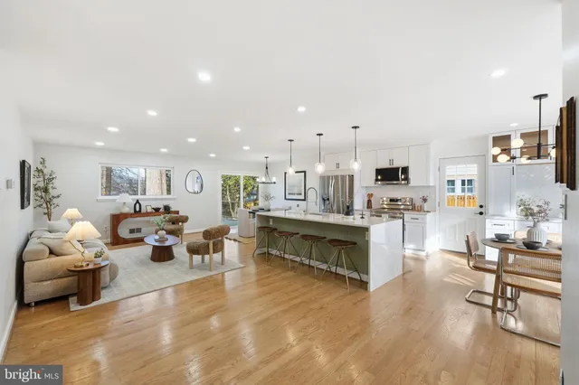a kitchen with kitchen island a sink and a stove top oven with wooden floor