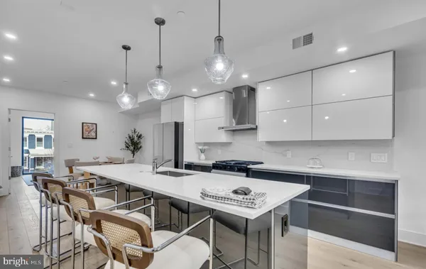 a kitchen with a table chairs and white cabinets