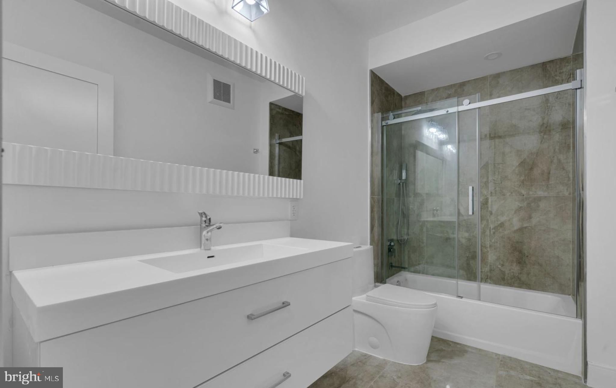 1121 Morse Street Northeast, Unit 2 Washington, DC 20002 - Photo 7 of 11 a bathroom with a sink a toilet and shower