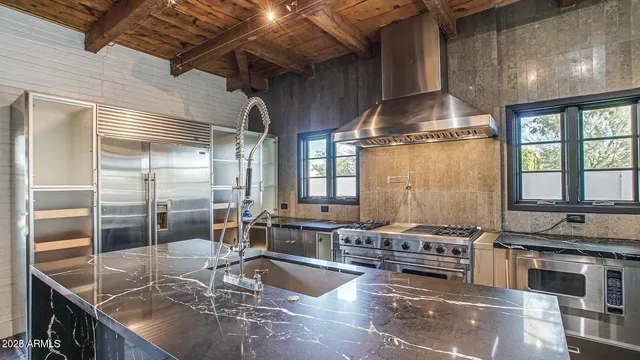 a kitchen with stainless steel appliances granite countertop a stove a sink and a refrigerator