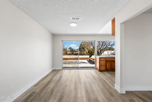 a view of a livingroom with wooden floor and a large window