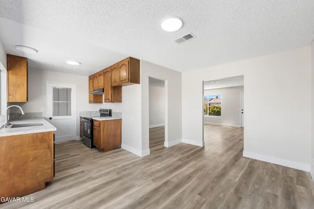a view of a kitchen with a sink cabinets and wooden floor