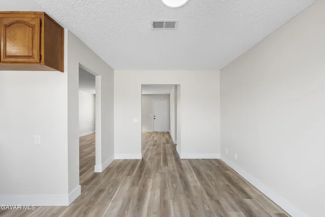 a view of a hallway with wooden floor and closet