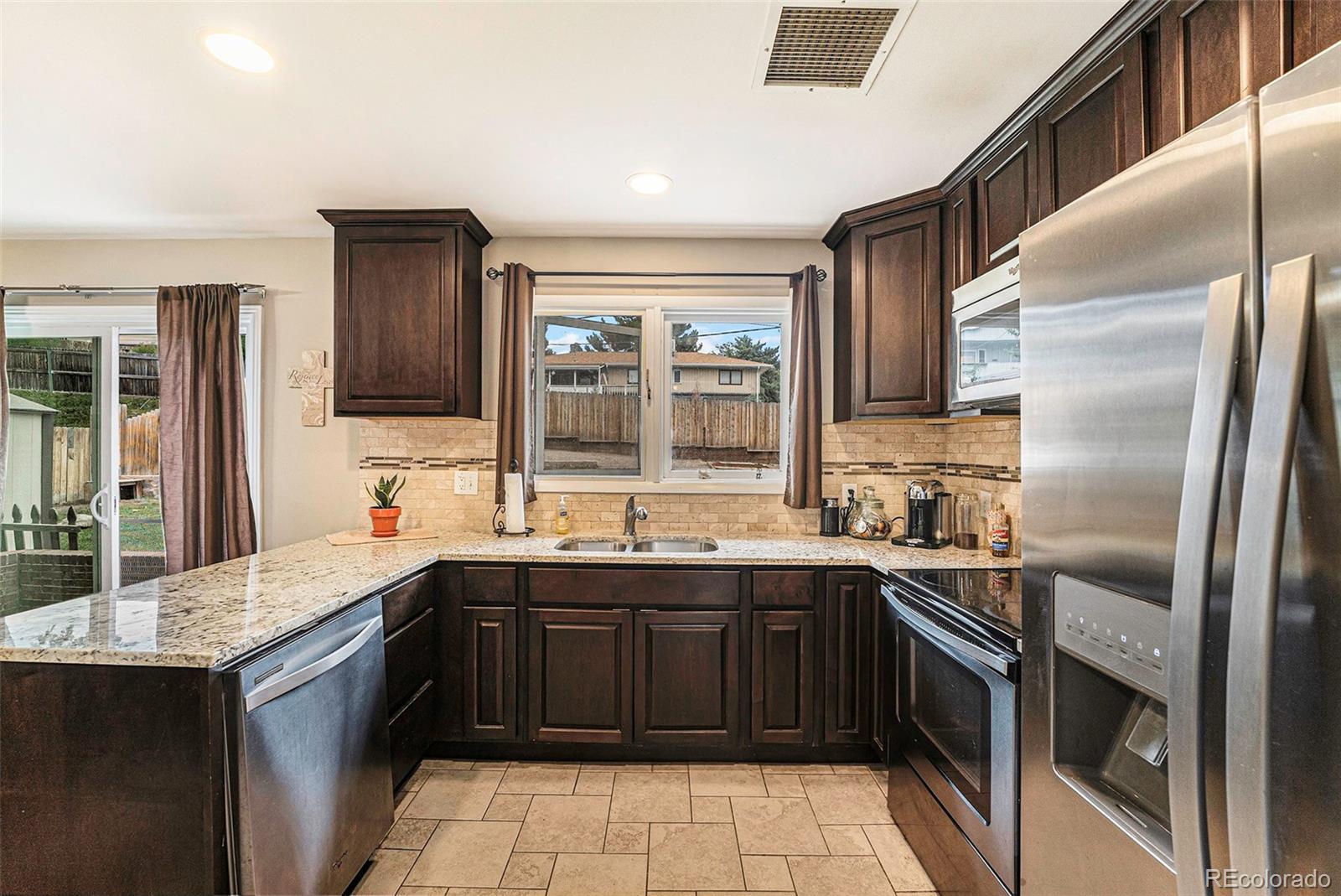 2872 South Gray Way Denver, CO 80227 - Photo 12 of 35 a kitchen with a sink stove and cabinets