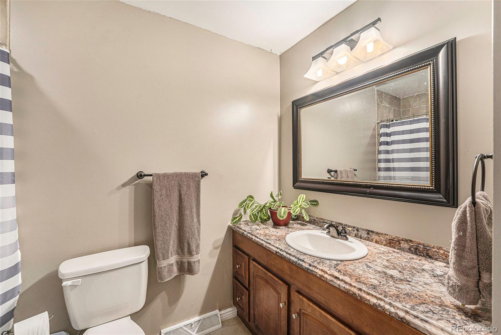 2872 South Gray Way Denver, CO 80227 - Photo 16 of 35 a bathroom with a granite countertop sink and a mirror