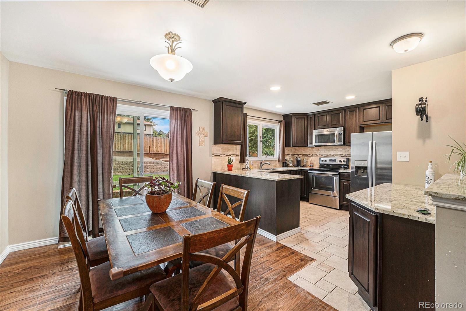 2872 South Gray Way Denver, CO 80227 - Photo 8 of 35 a kitchen with a table chairs refrigerator and microwave