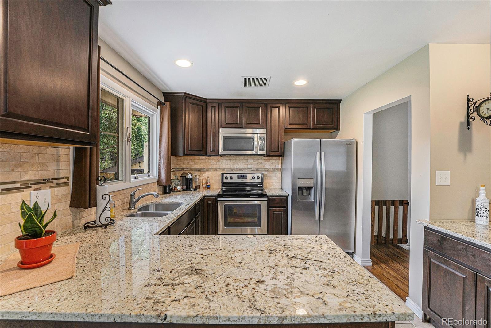 2872 South Gray Way Denver, CO 80227 - Photo 10 of 35 a kitchen with stainless steel appliances granite countertop a refrigerator a stove and a sink