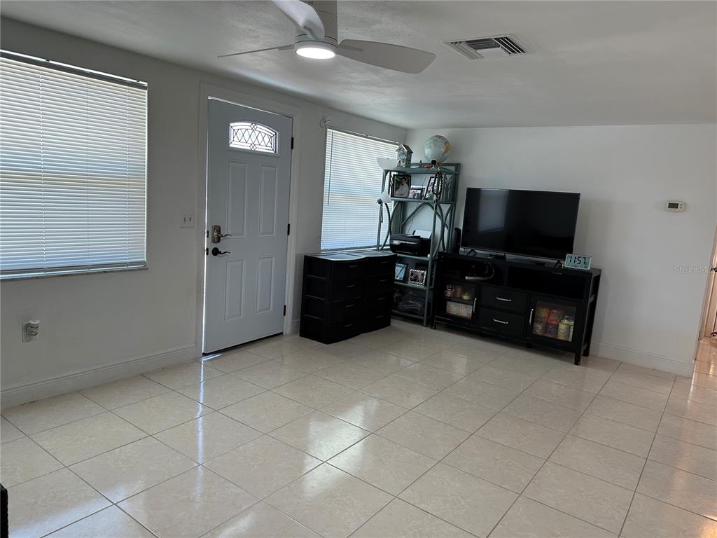 12613 4th Isle Hudson, FL 34667 - Photo 5 of 42 a living room with furniture and a flat screen tv