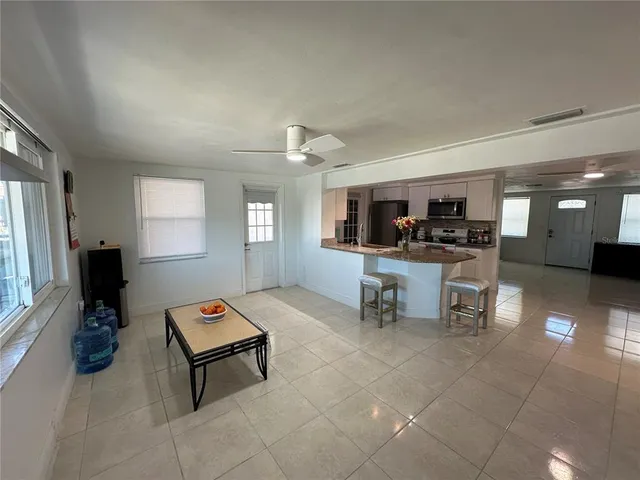 a view of a kitchen with a sink and dishwasher a kitchen island with chairs