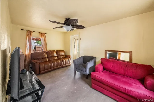 a living room with furniture a ceiling fan and a rug