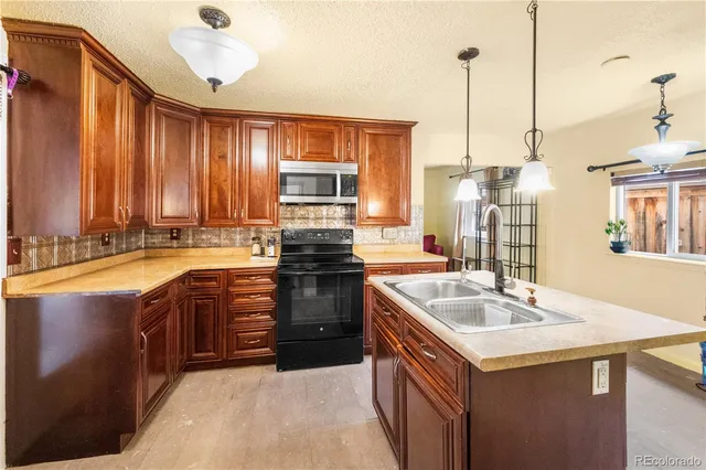 a kitchen with kitchen island granite countertop a sink appliances and cabinets