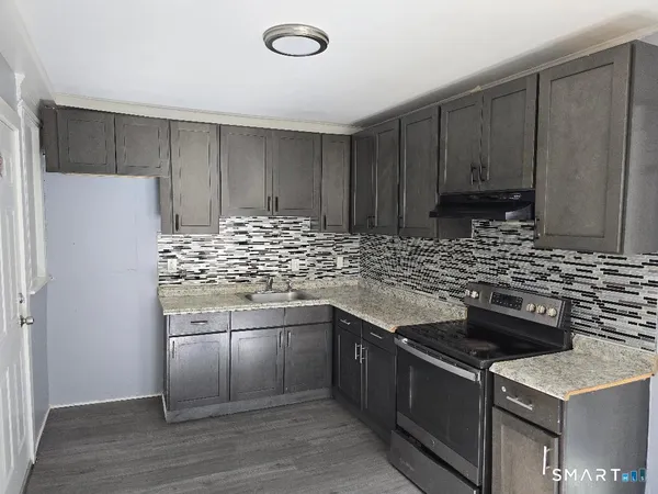 a kitchen with stainless steel appliances granite countertop a stove and a refrigerator