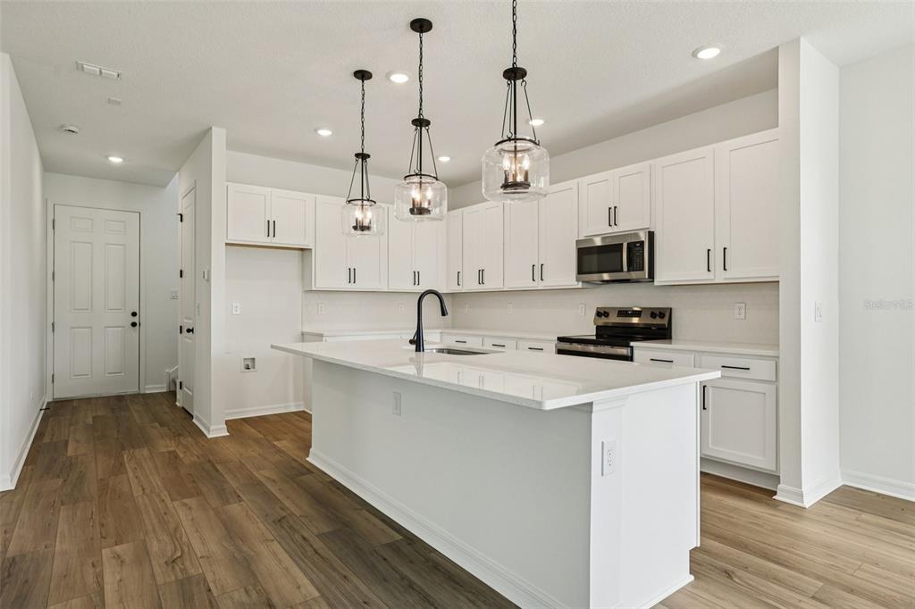2491 Zuni Road St. Cloud, FL 34771 - Photo 11 of 42 a kitchen with kitchen island a sink stainless steel appliances and white cabinets