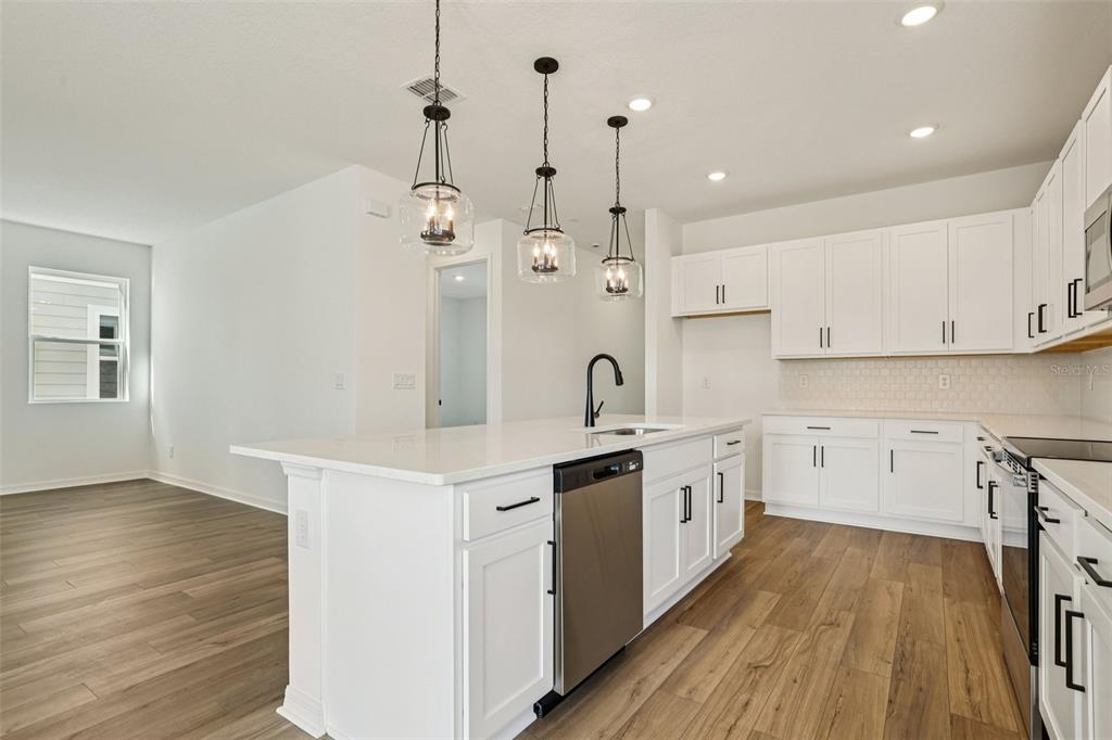 2491 Zuni Road St. Cloud, FL 34771 - Photo 13 of 42 a large kitchen with stainless steel appliances sink a large window and wooden floor