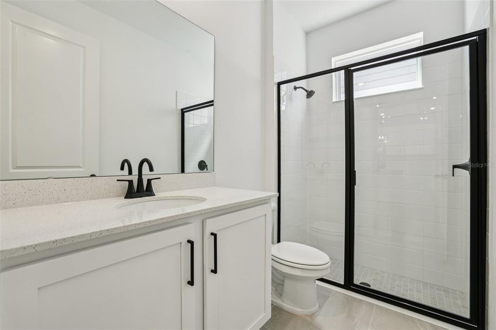 2491 Zuni Road St. Cloud, FL 34771 - Photo 19 of 42 a bathroom with a shower sink vanity mirror and toilet