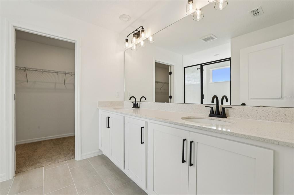 2491 Zuni Road St. Cloud, FL 34771 - Photo 33 of 42 a bathroom with a double vanity sink and a mirror