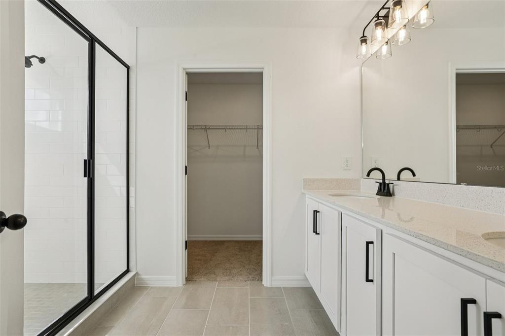 2491 Zuni Road St. Cloud, FL 34771 - Photo 34 of 42 a spacious bathroom with a double vanity sink a mirror and shower
