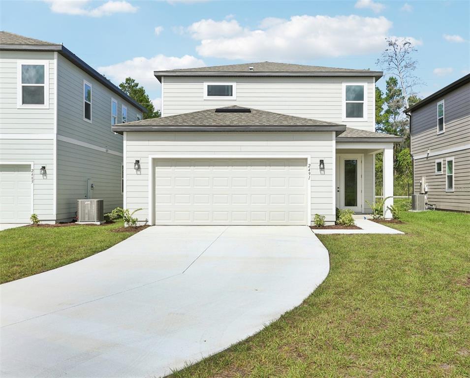 2491 Zuni Road St. Cloud, FL 34771 - Photo 39 of 42 a front view of a house with a yard and garage