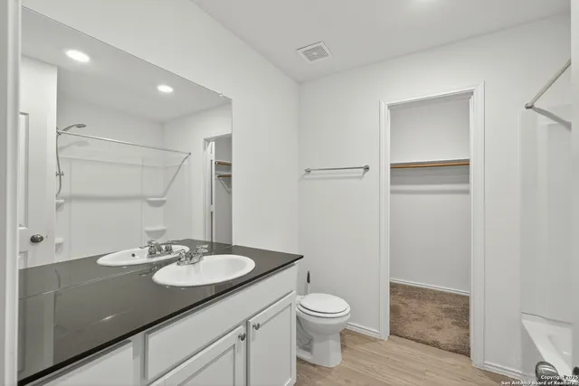 a bathroom with a granite countertop sink toilet and shower