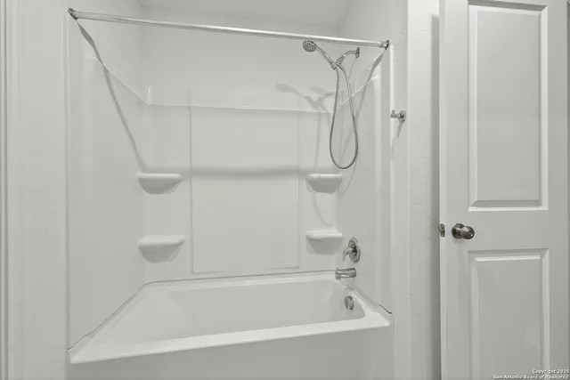 a bathroom with a bath tub with a shower