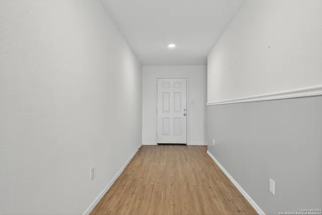 a view of a room with wooden floor and bench
