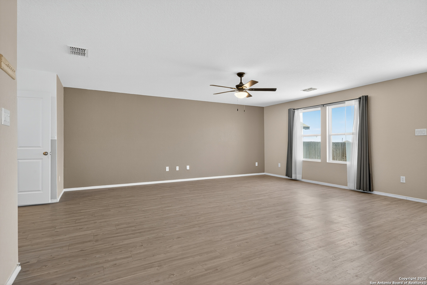 10716 Sweepback Trail Converse, TX 78109 - Photo 4 of 26 a view of an empty room with wooden floor and a window