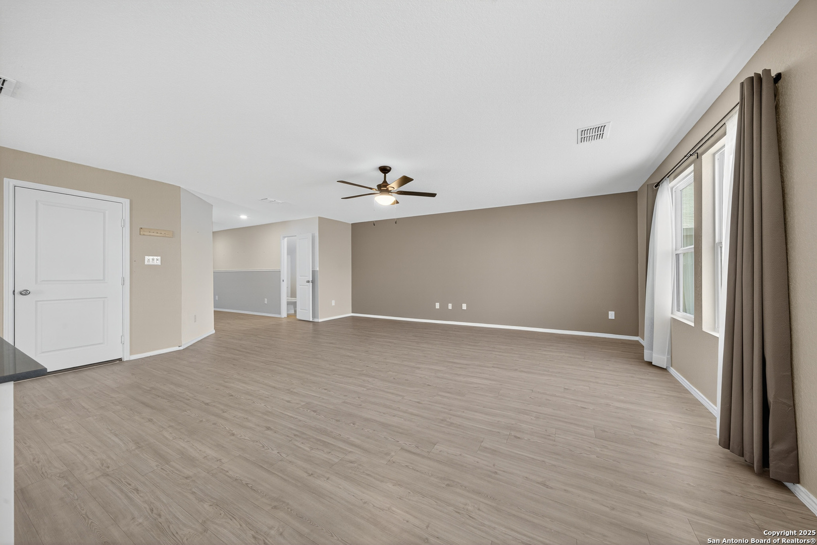 10716 Sweepback Trail Converse, TX 78109 - Photo 6 of 26 a view of an empty room with wooden floor and a window