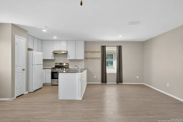 a kitchen with stainless steel appliances granite countertop a refrigerator sink and stove
