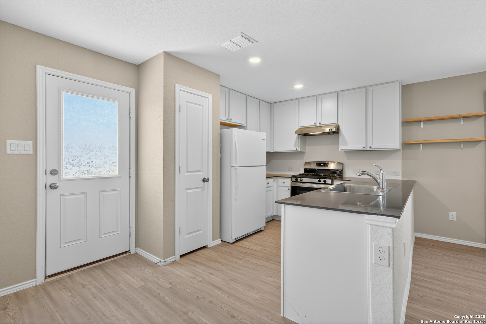 10716 Sweepback Trail Converse, TX 78109 - Photo 9 of 26 a kitchen with a refrigerator sink and cabinets