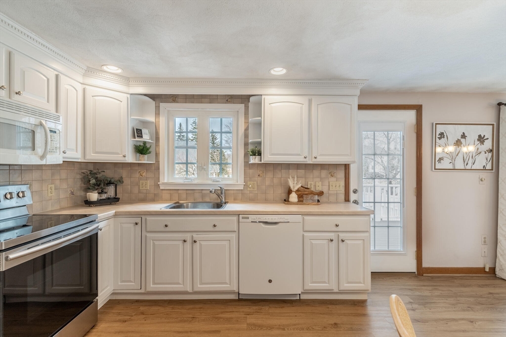 2 Rodgers Road Stoneham, MA 02180 - Photo 14 of 38 a kitchen with stainless steel appliances granite countertop a stove a sink and white cabinets