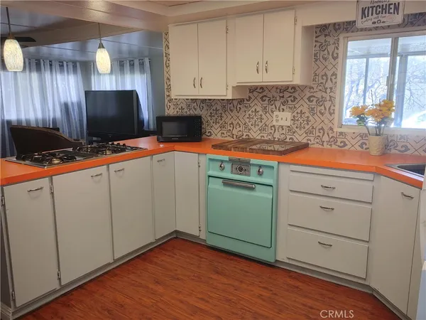 a kitchen with cabinets and wooden floor