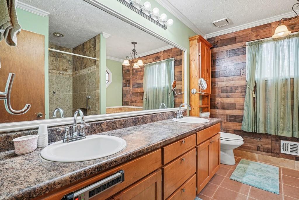 114 Copeland Lane Stockbridge, GA 30281 - Photo 6 of 40 a bathroom with a granite countertop sink a toilet a mirror and shower
