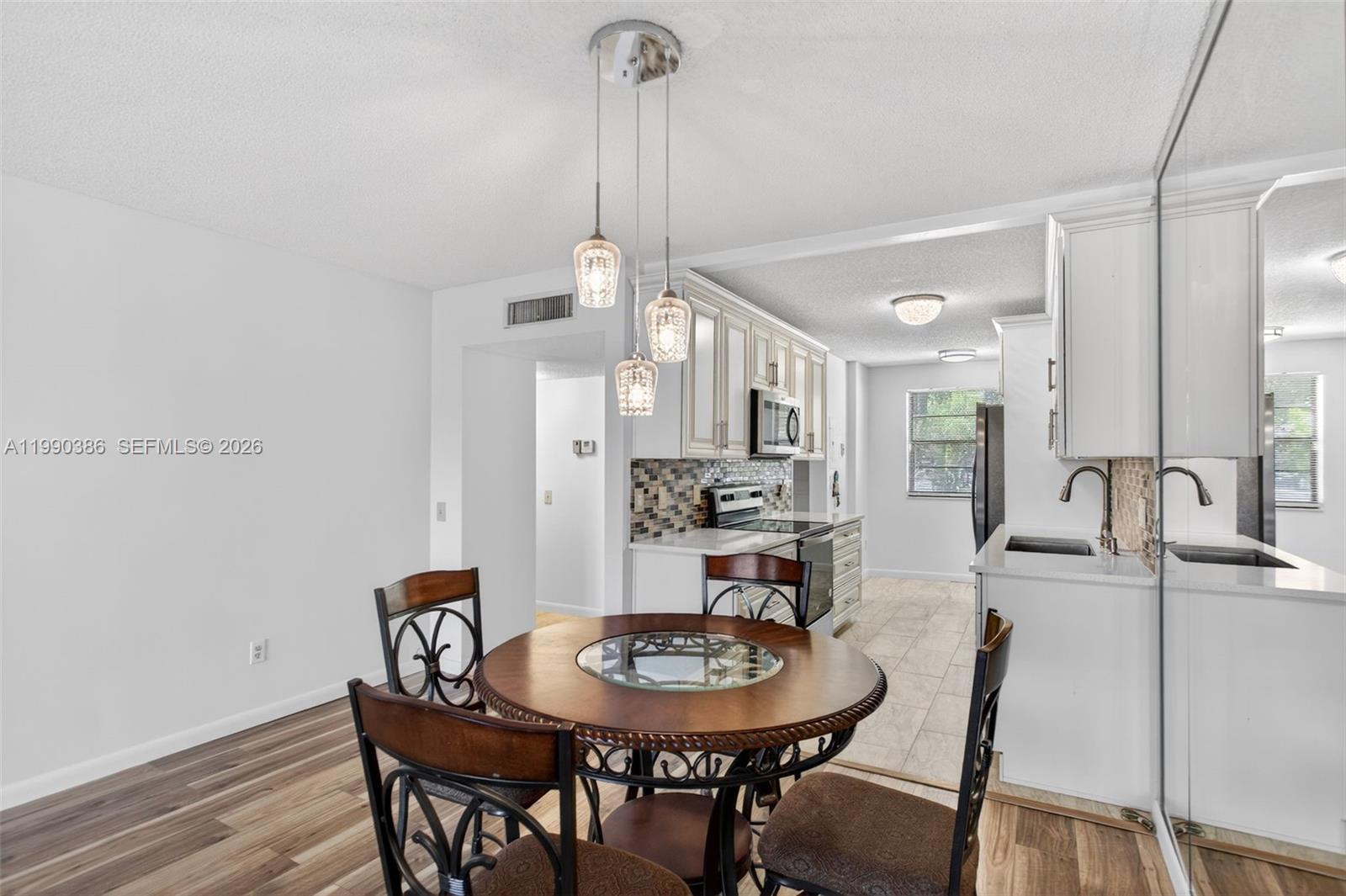 9670 West McNab Road, Unit 208 Tamarac, FL 33321 - Photo 14 of 47 a view of a dining room with furniture and wooden floor