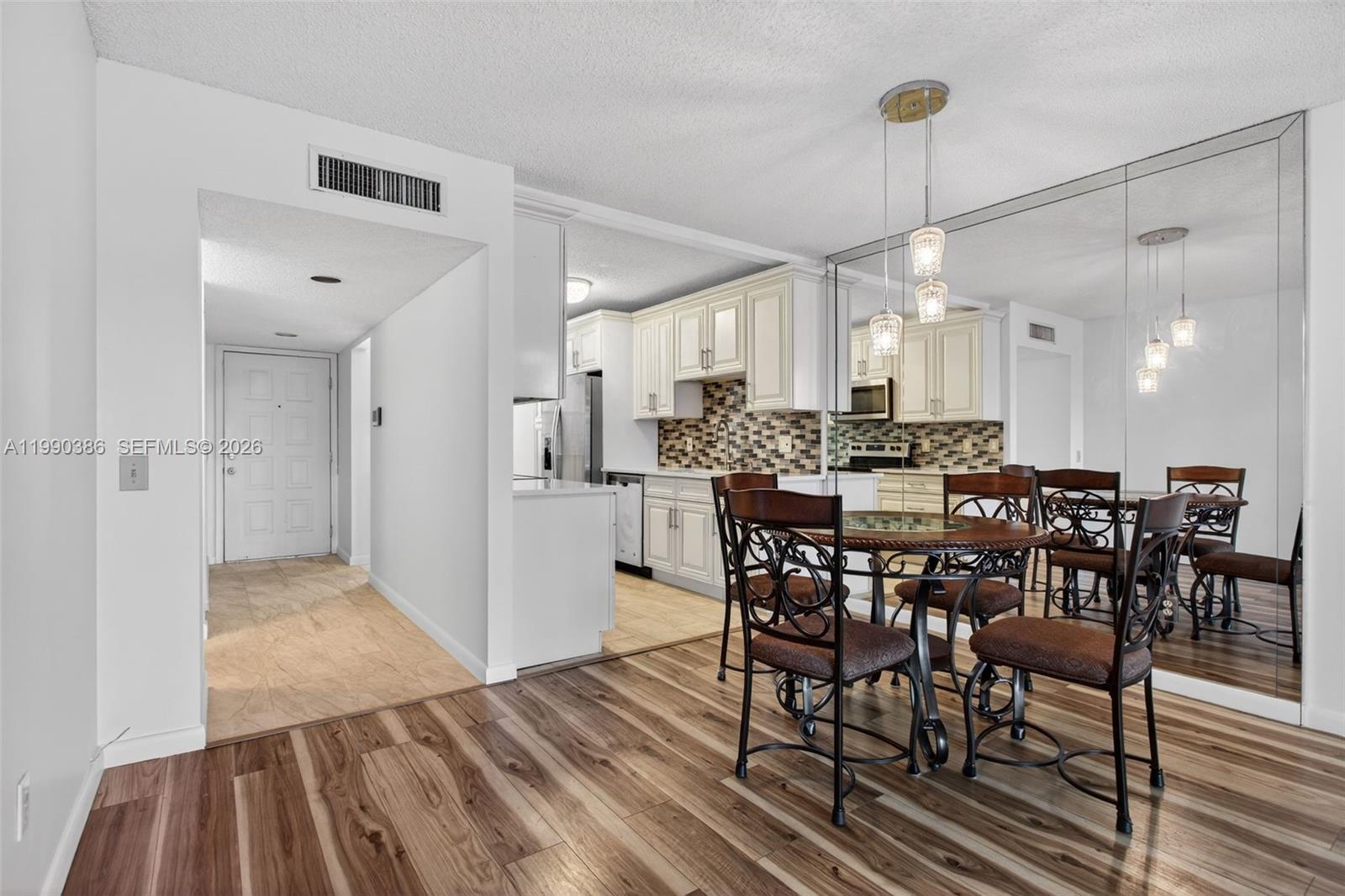 9670 West McNab Road, Unit 208 Tamarac, FL 33321 - Photo 15 of 47 a view of a dining room and livingroom with furniture wooden floor a chandelier