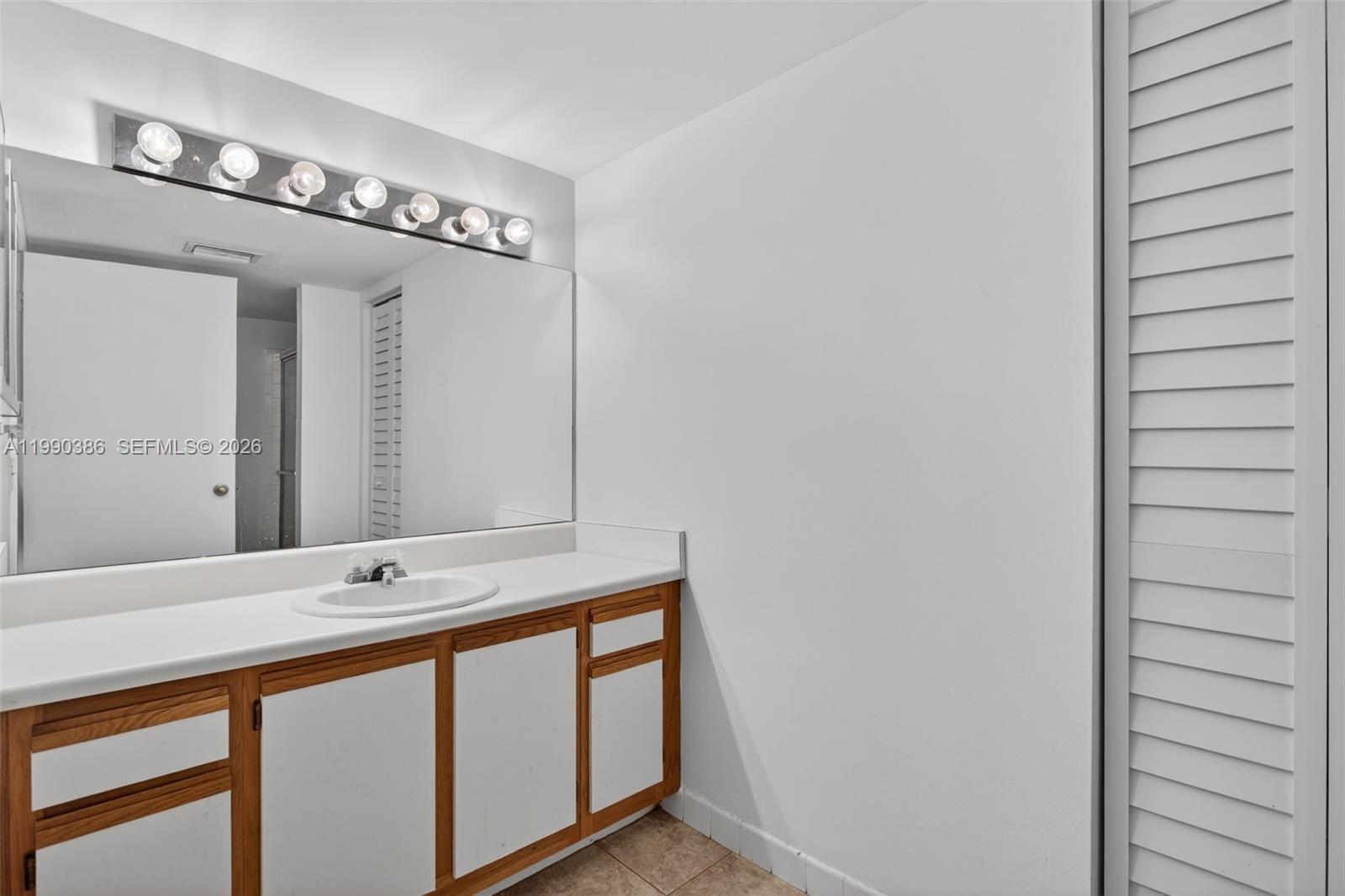 9670 West McNab Road, Unit 208 Tamarac, FL 33321 - Photo 26 of 47 a bathroom with a sink and a mirror