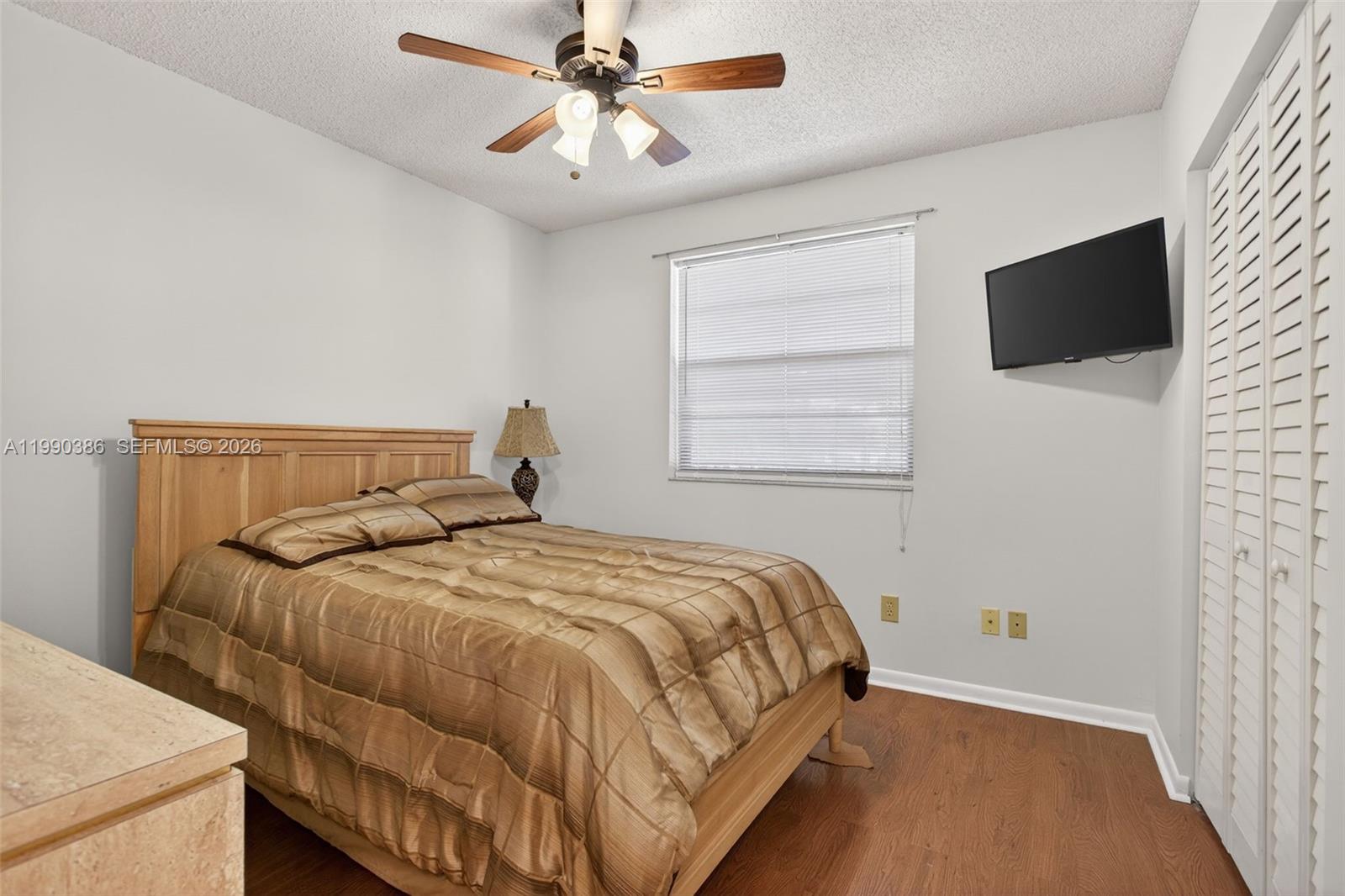 9670 West McNab Road, Unit 208 Tamarac, FL 33321 - Photo 28 of 47 a bedroom with a bed and a flat screen tv