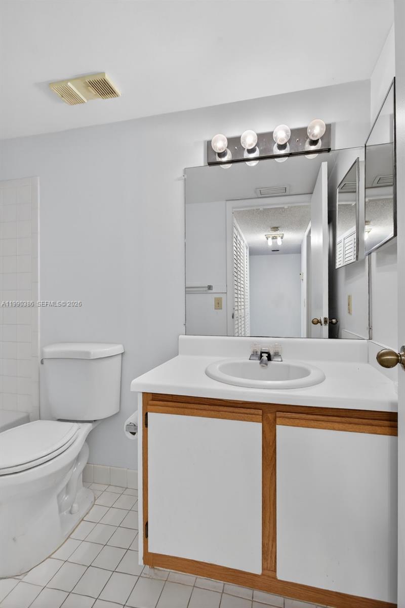 9670 West McNab Road, Unit 208 Tamarac, FL 33321 - Photo 33 of 47 a bathroom with a sink toilet and mirror