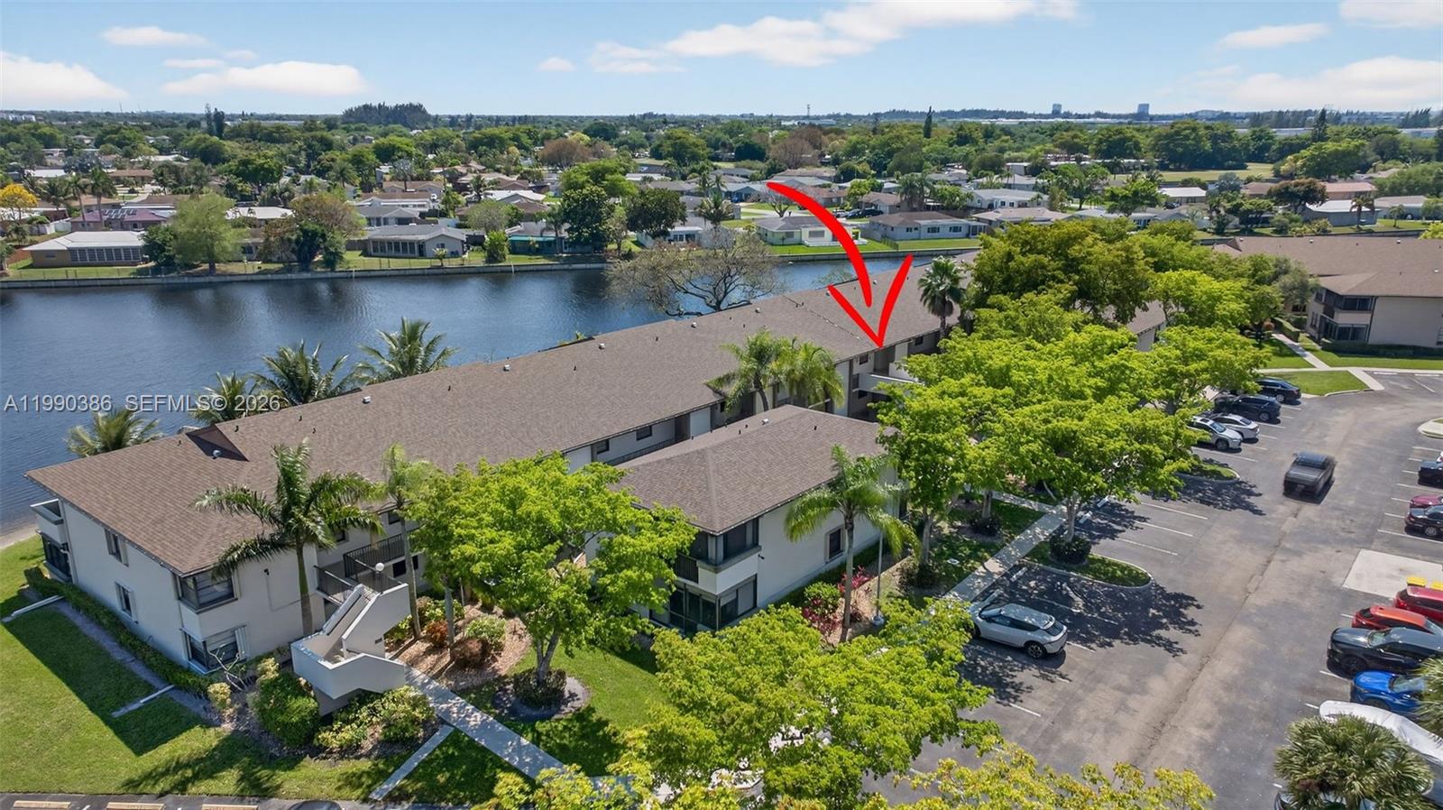 9670 West McNab Road, Unit 208 Tamarac, FL 33321 - Photo 36 of 47 an aerial view of a house with a lake and a residential building in the back
