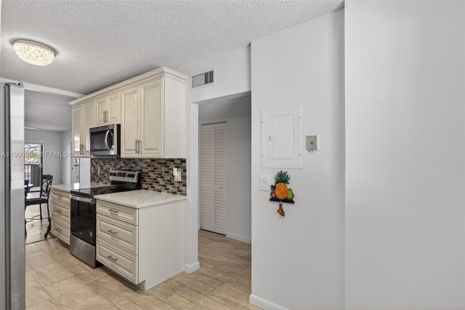 9670 West McNab Road, Unit 208 Tamarac, FL 33321 - Photo 5 of 47 a kitchen with a refrigerator and a stove top oven