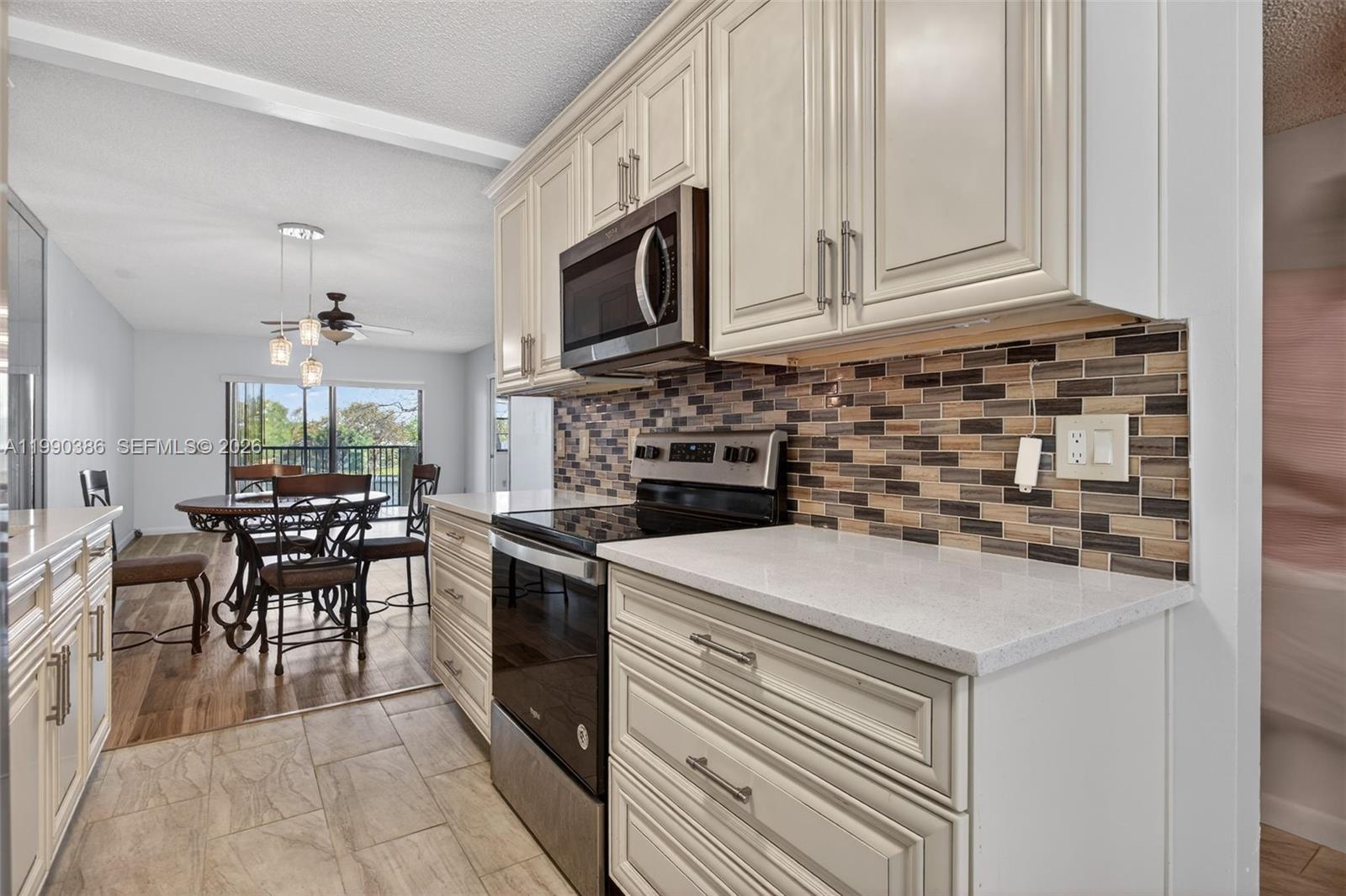 9670 West McNab Road, Unit 208 Tamarac, FL 33321 - Photo 6 of 47 a kitchen with a stove and white cabinets