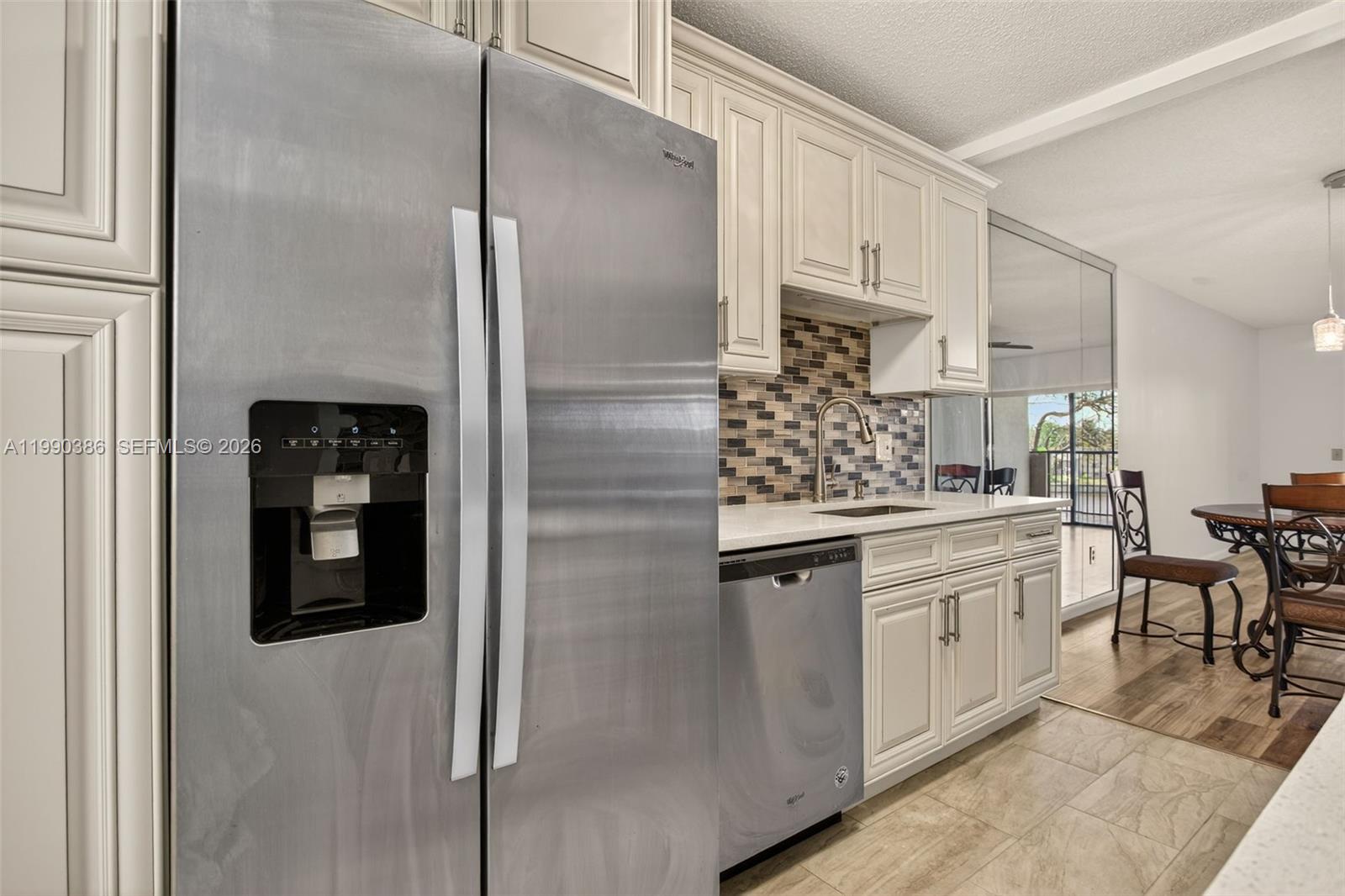 9670 West McNab Road, Unit 208 Tamarac, FL 33321 - Photo 7 of 47 a kitchen with stainless steel appliances granite countertop a refrigerator and white cabinets