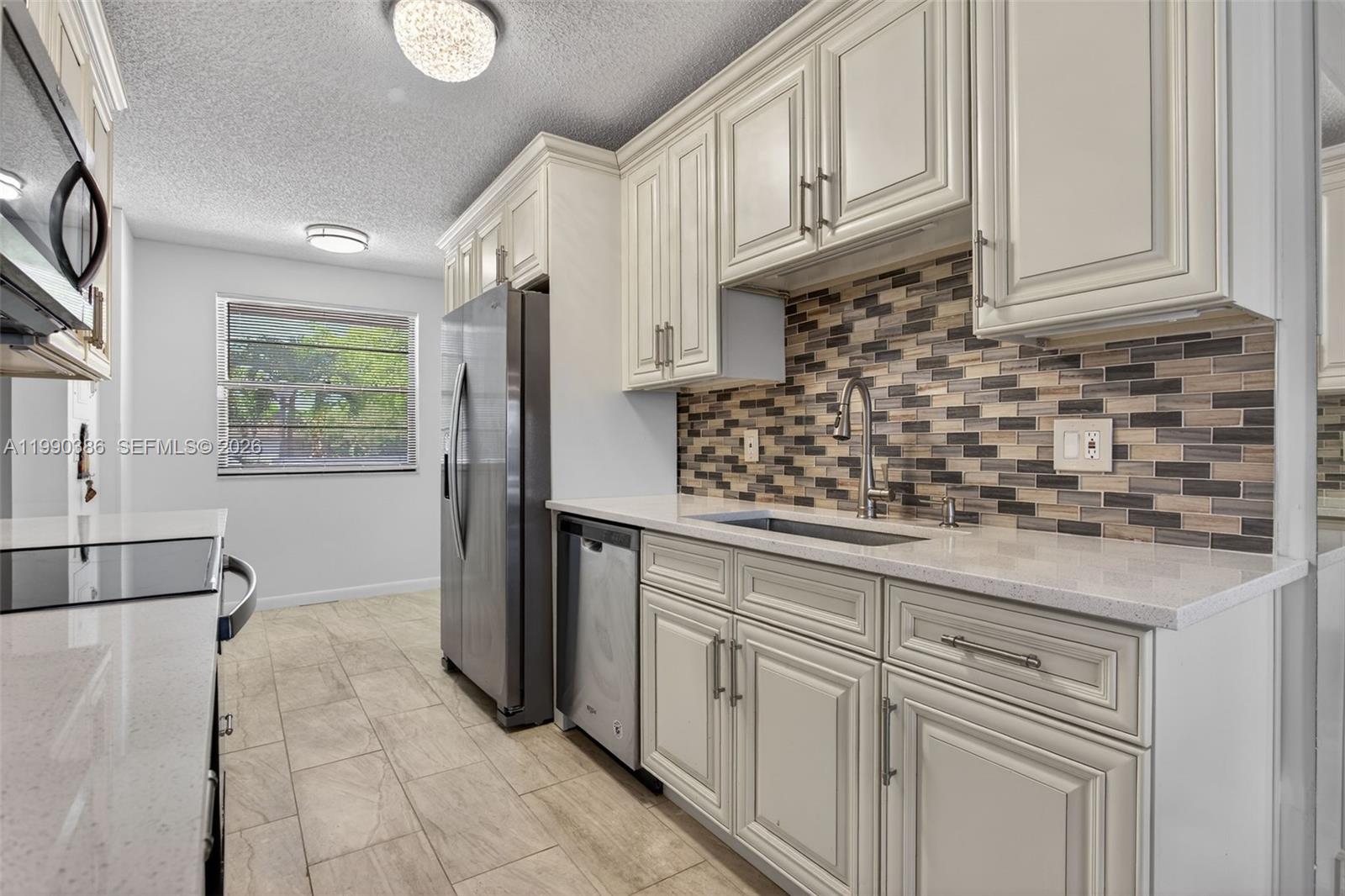 9670 West McNab Road, Unit 208 Tamarac, FL 33321 - Photo 8 of 47 a kitchen with stainless steel appliances granite countertop a sink stove and cabinets