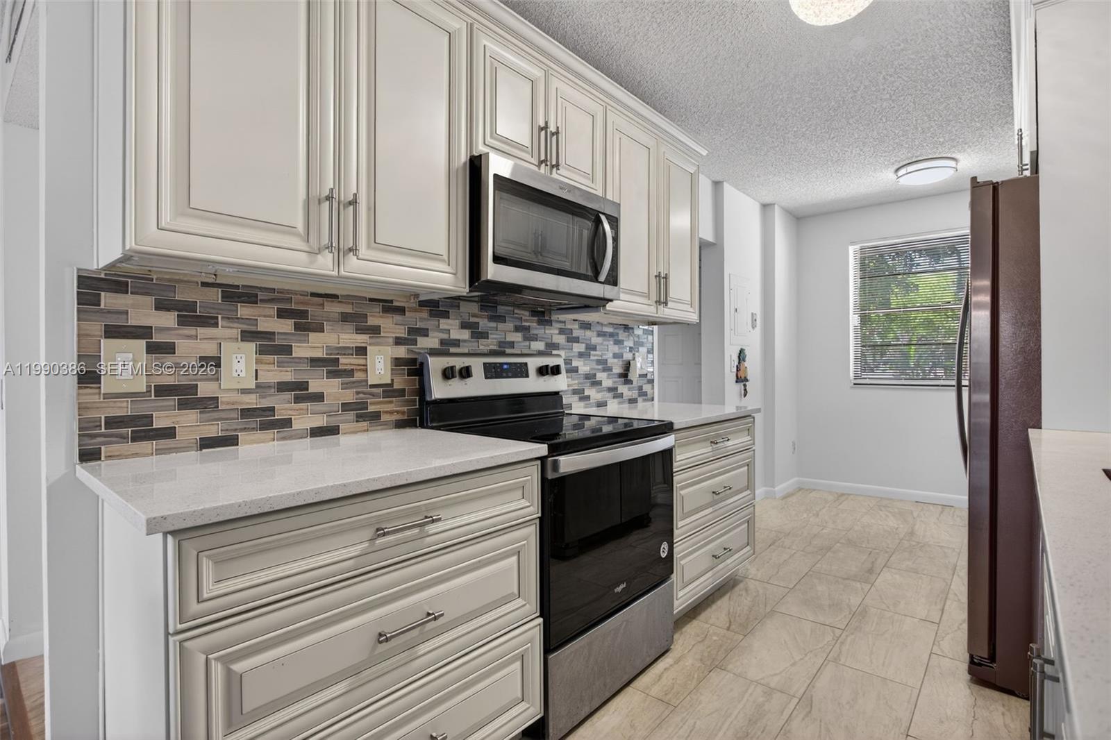 9670 West McNab Road, Unit 208 Tamarac, FL 33321 - Photo 9 of 47 a kitchen with stainless steel appliances granite countertop white cabinets and a stove