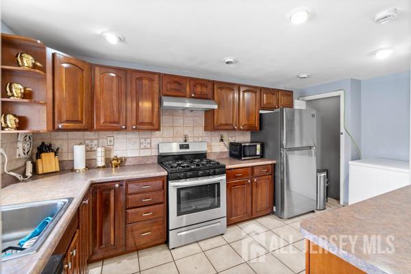 285 Water Street Perth Amboy, NJ 08861 - Photo 4 of 16 a kitchen with stainless steel appliances granite countertop a stove top oven a refrigerator and a sink with granite countertops