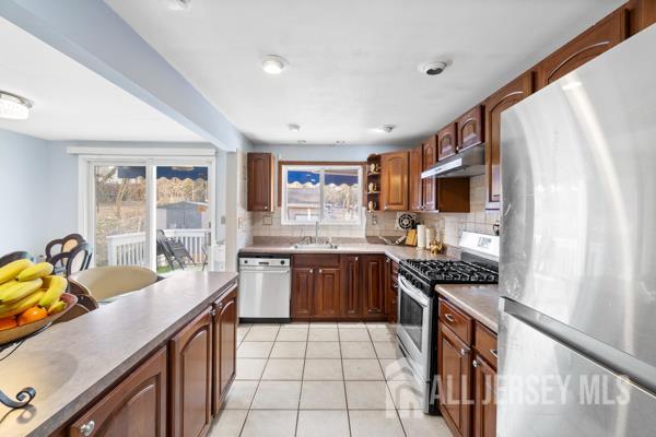 285 Water Street Perth Amboy, NJ 08861 - Photo 5 of 16 a kitchen with stainless steel appliances granite countertop a stove a sink and a microwave